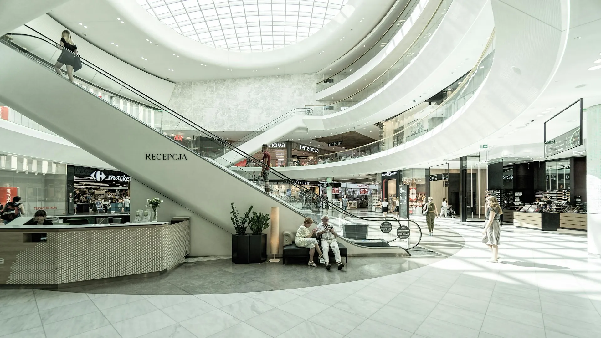 Geniş atriumlu, aydınlık bir alışveriş merkezi